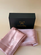 Folded pink satin fabric with LuxSila logo on a beige background
blush pink