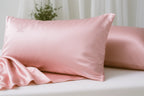 Pink silk pillowcase on a white surface with a blurred background
#color_blush pink