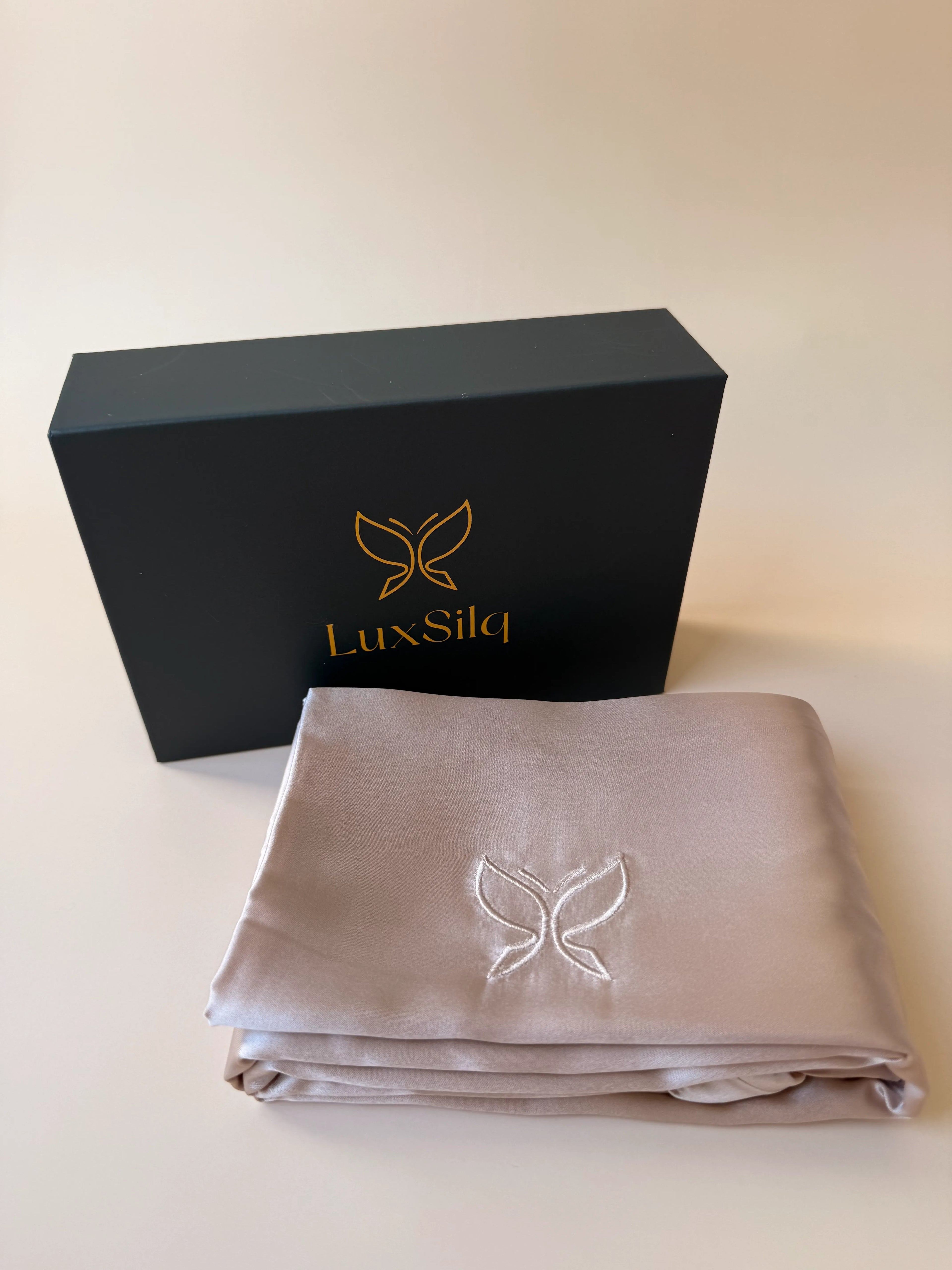 LuxSilq satin sheet set with branded box on a light background
golden sand