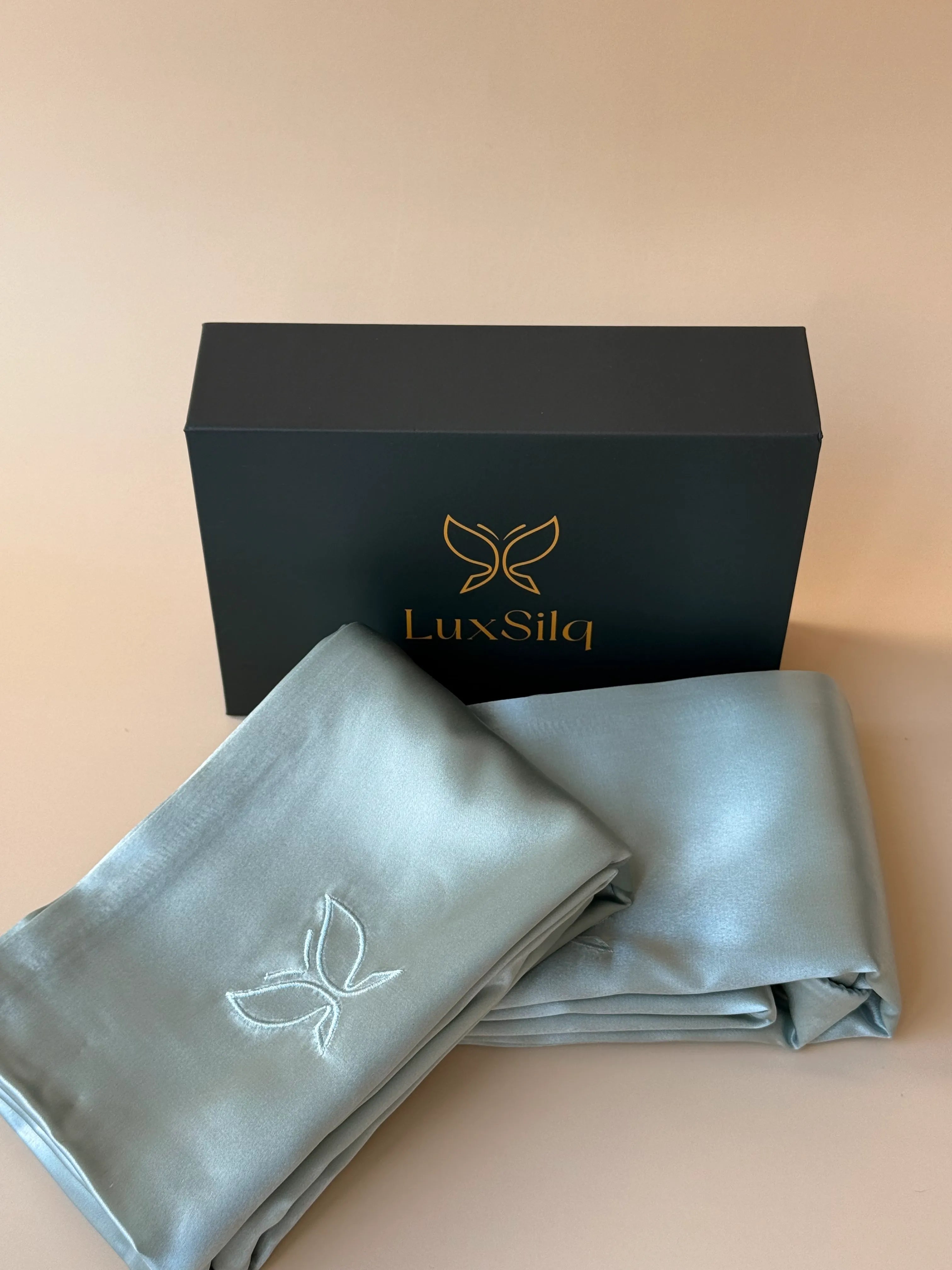 LuxSila branded box with a folded gray fabric item on a beige background
sea foam blue